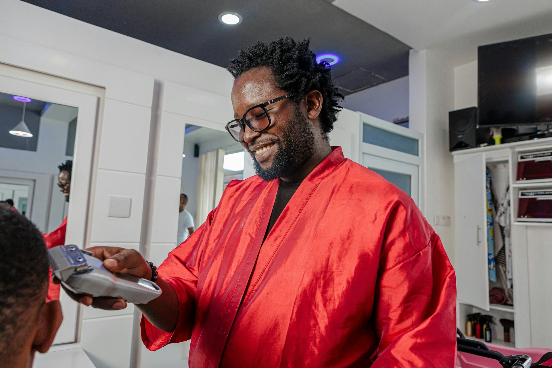 a man in a red robe smiles as he holds a clipboard